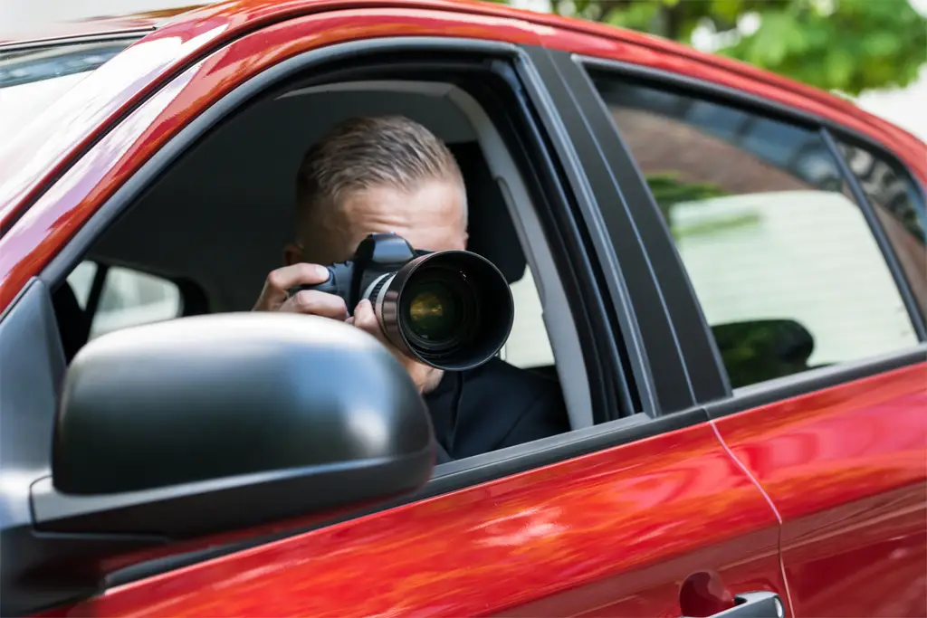 Paparazzi taking a photo from a car.