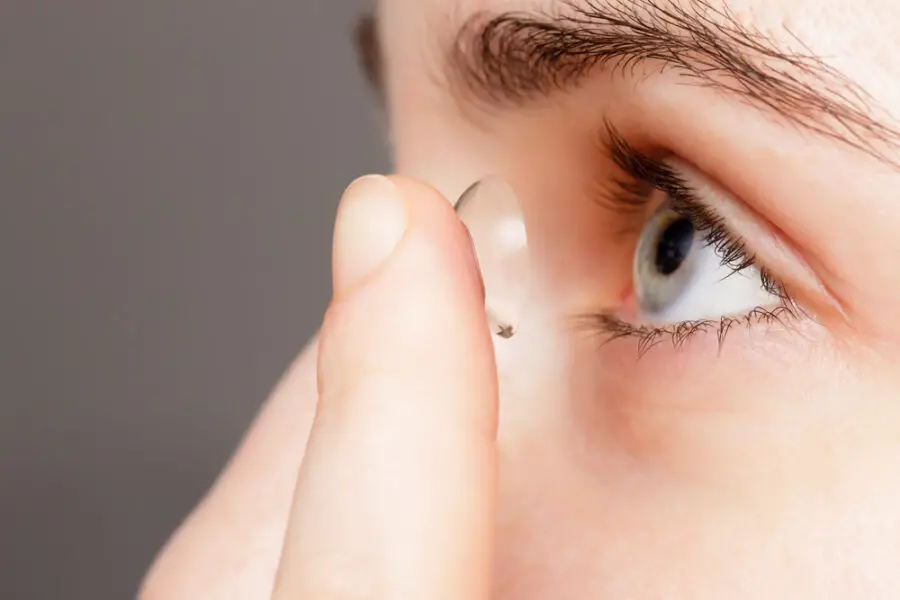 Girl putting in contact lens