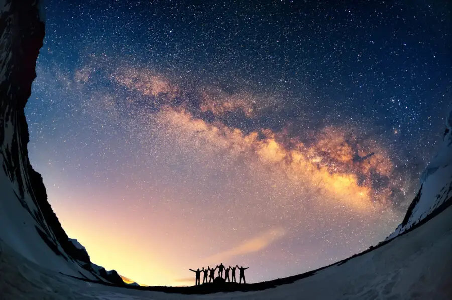 Group standing in front of the Milky Way to depict the color of the universe